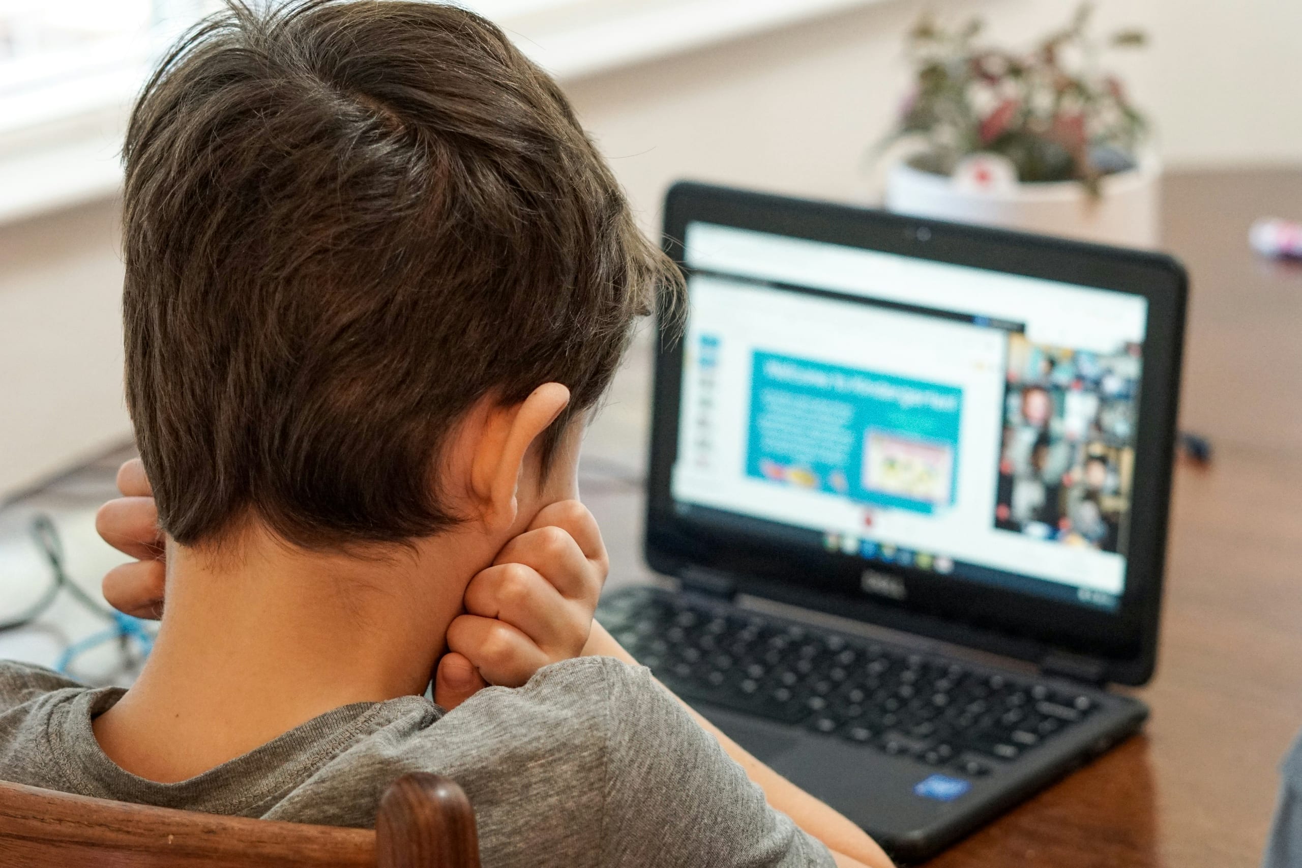 A child working at a laptop on their schoolwork
